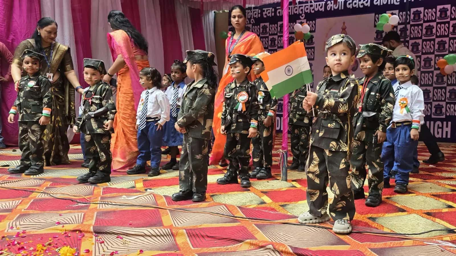 Young students in costume with the national flag at a school programme